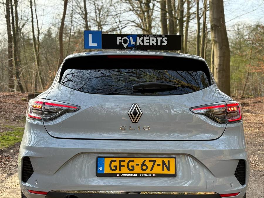 Achterkant van de lesauto van Autorijschool Folkerts met het blauwe L-bord en het lesbord op het dak