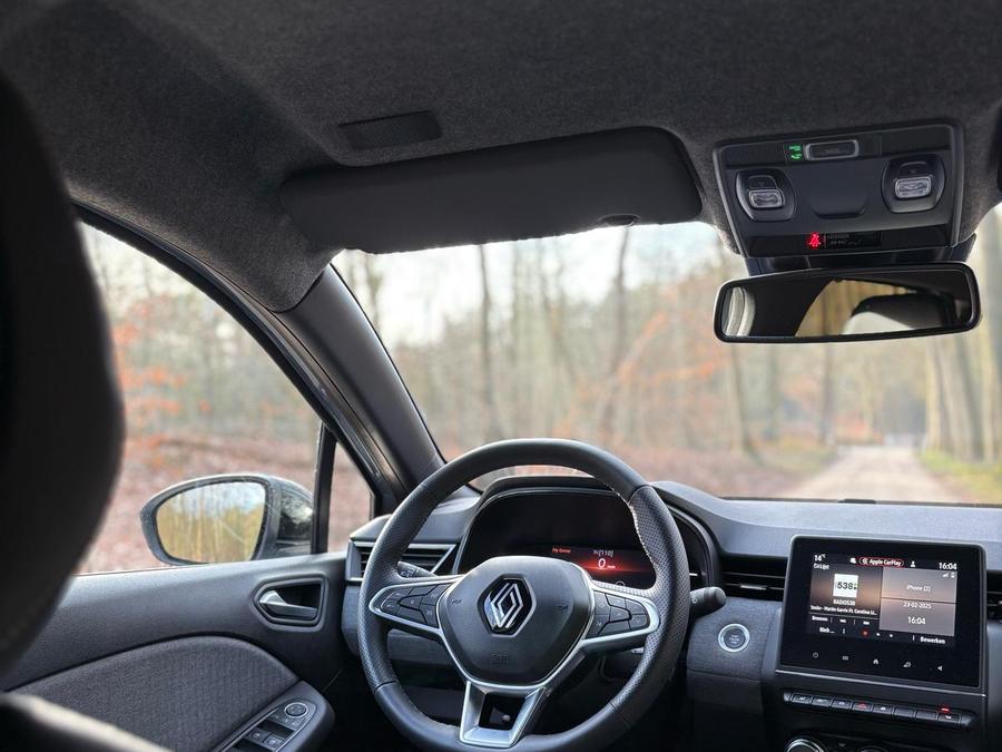 Interieur van de lesauto: stuur, digitaal dashboard en handgeschakelde versnellingsbak van de Renault Clio